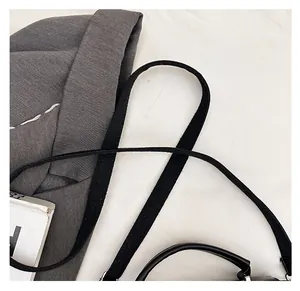 Detail of the durable woven nylon shoulder strap and handle on a black leather handbag