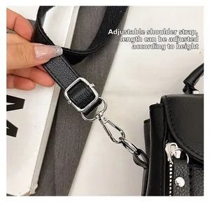 Detail of adjustable shoulder strap on black lychee leather bag with silver buckle