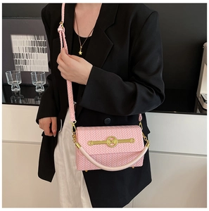 Detail of pink woven texture shoulder bag with gold M buckle and metal bar
