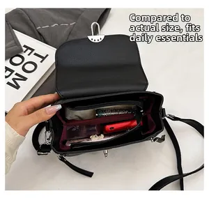 Top view of black crossbody bag showing spacious interior with burgundy lining and lock detail