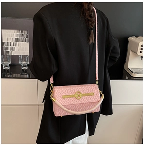 Detailed close-up of pink woven leather box bag featuring golden M logo and metal hardware