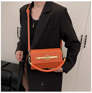 Detail of orange woven crossbody bag with gold M logo and adjustable shoulder strap