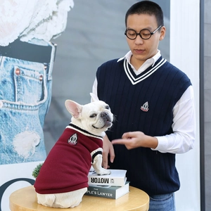 Detail of burgundy knit pet vest and matching adult navy vest with crown embroidery