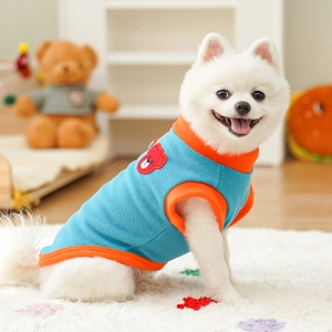 Close-up of sky blue fleece pet vest with orange trim and red bear embroidery