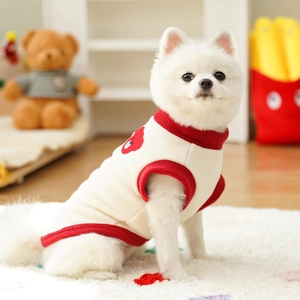 Detail of fleece pet vest featuring red trim and cute bear embroidery on white dog coat