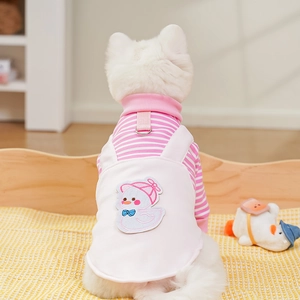Close-up of pink striped dog overalls with cartoon duck embroidery on soft cotton fabric