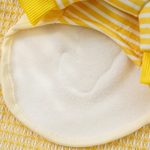 Close-up of warm white fleece lining and yellow striped fabric on a pet sweater