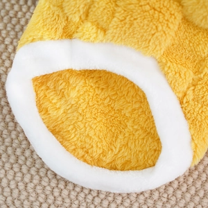 Close-up of soft yellow plush pet clothes fabric with thick white fleece edging details