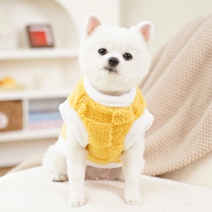 Close-up of warm ginger plush pet vest with white fleece trim and soft texture