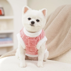 Close-up of pink plush pet vest with high white collar and soft fleece texture