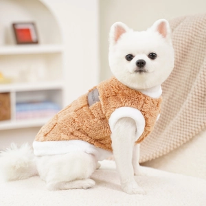 Close-up of brown plush pet vest with white fleece edges and fashion leather tag