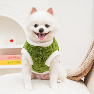 Close-up of green fleece dog vest with plush white trim and warm sherpa texture