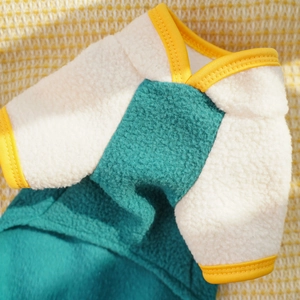 Detail of fleece pet jumpsuit with color-block green and cream fabric and yellow trim