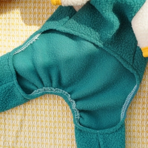Macro detail of warm fleece pet jumpsuit showing neat white edge stitching and textures
