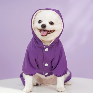 Detail of purple waterproof pet raincoat featuring white buttons and elasticated cuffs