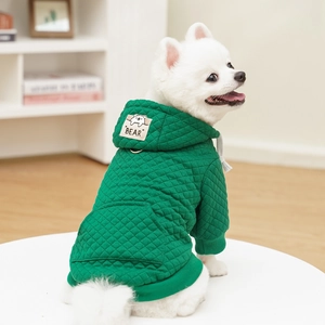 Detail eines grünen gesteppten Haustier-Hoodies mit Bären-Aufnäher und D-Ring am Hund