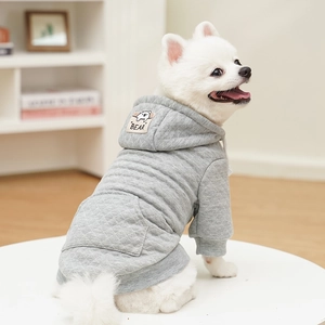 Detail eines grauen gesteppten Hunde-Hoodies mit Bären-Label und Kapuze für kleine Hunde