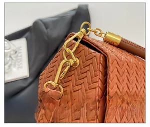 Detailed close-up of premium gold-tone hardware and brown woven texture on a handbag