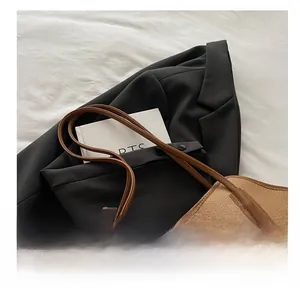 Detail of coffee brown tote bag showing premium lychee grain leather and stitching