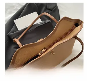 Detailed view of brown lychee leather tote bag with gold zipper and spacious interior