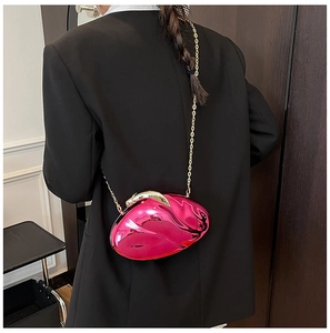 Detailed view of the metallic rose pink hardshell round crossbody bag with gold chain strap