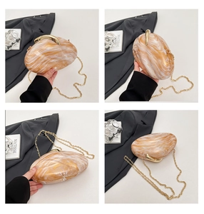 Macro detail of marble-textured shell bag with metallic gold clasp and chain strap