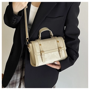 Gros plan du sac Boston vintage beige mat avec boucle dorée et coutures de précision