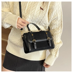 Détail du sac bandoulière vintage noir montrant le cuir et la boucle dorée