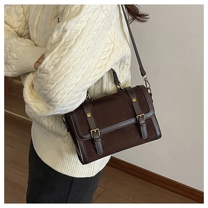 Détail du sac Boston vintage marron avec boucles dorées et vue latérale sur le mannequin