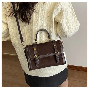 Détail du sac à main rétro marron avec boucles dorées et texture patchwork chic
