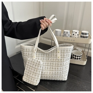 Detail of tweed tote bag with yellow and green weaving and small matching pouch