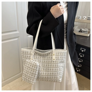 Detail of white tweed tote bag with gold thread weaving and matching small pouch
