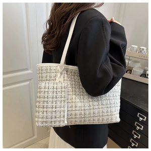 Detail view of large tweed tote bag with matching zipper pouch in cream woven texture