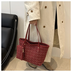 Close-up of red tweed tote bag with matching pouch and gold hardware details