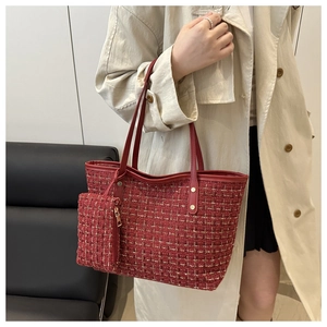 Détail du cabas en tweed rouge avec ferrures dorées et pochette zippée assortie