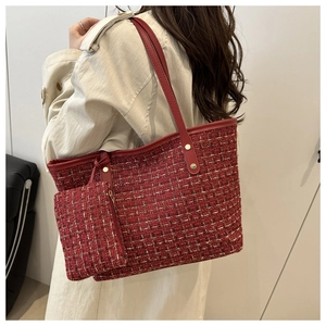 Detail of red tweed tote bag with gold stud accents and matching zipper pouch charm