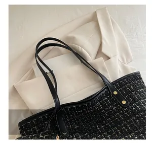 Detail of tweed tote bag featuring gold metallic threads and black leather straps with rivets