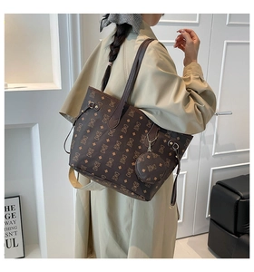 Détail d'un sac cabas marron foncé imprimé avec une pochette assortie et des sangles