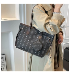 Close-up of contrast tote bag featuring bear monogram pattern and detachable round coin purse