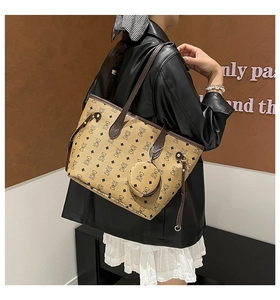 Detailed back view of a brown monogram tote bag with bear pattern on a fashion model