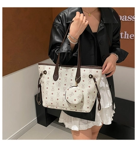 Détail du sac fourre-tout crème avec imprimé ours et petit charme sur veste en cuir
