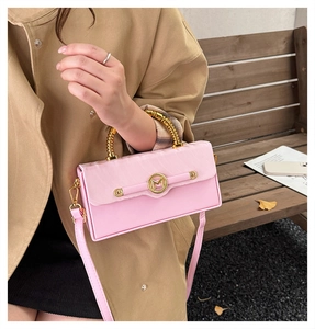 Pink box bag featuring golden bamboo metal handle and decorative 'M' logo buckle