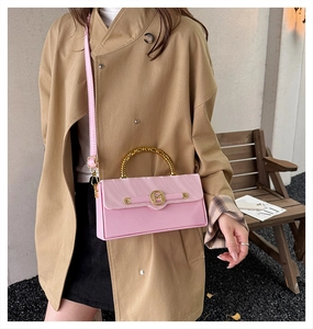 Pink leather handbag with gathered detail, bamboo handle and gold M logo on the cover