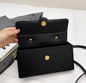 Detail of black box bag showing magnetic snap closure and golden hardware components