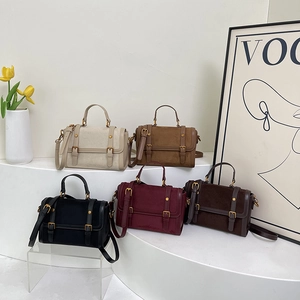 Sacs Boston rétro en velours mat de cinq couleurs sur un présentoir blanc