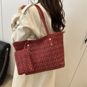 Elegant wine red tweed tote bag set with gold thread detail worn with a trench coat