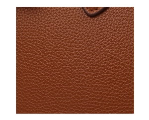 Macro shot of brown lychee grain leather texture with stitching on a fashion tote bag