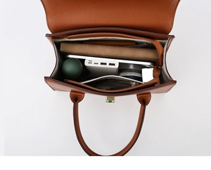 Top view of brown leather tote showing spacious interior with zip divider and side pockets