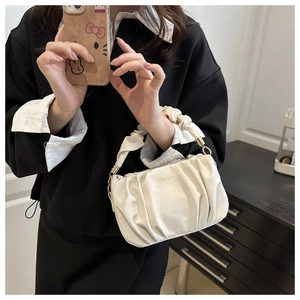 Gros plan du sac à main blanc plissé avec logo doré et détail de la poignée texturée