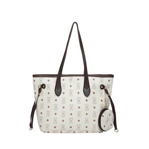 Cream tote bag with brown bear patterns and a matching small round coin purse charm